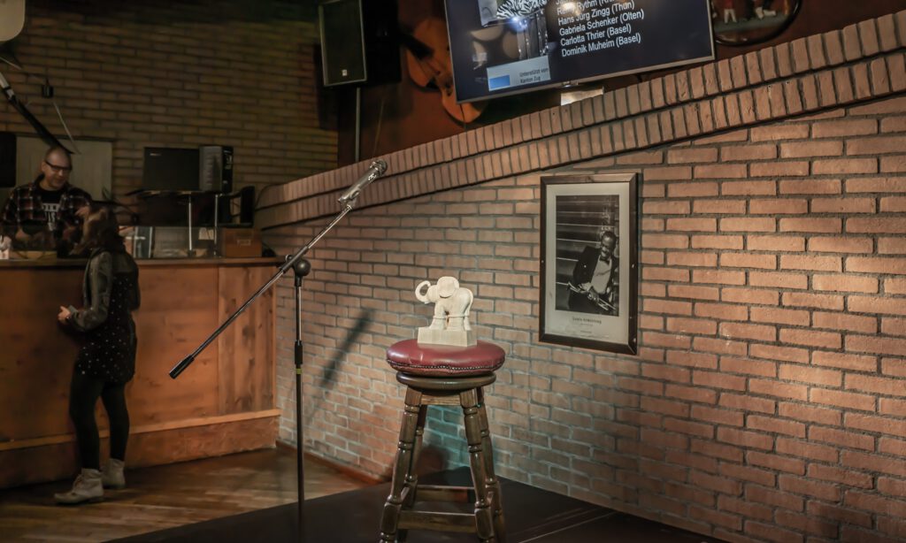 Empty Poetry Slam microphone setup with stool and audience area