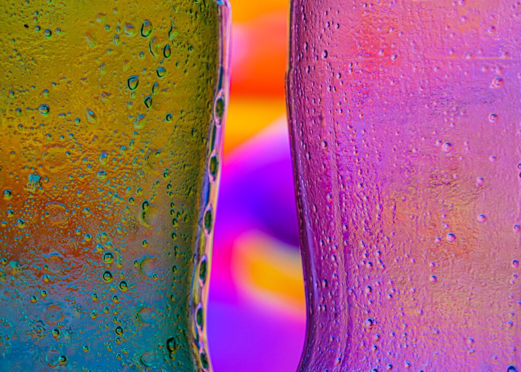 Close-up of yellow and purple glass bottles covered with condensation