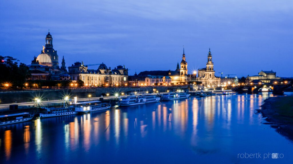 Dresden riverfront skyline illuminated at blue hour with reflections on the water