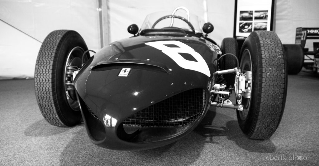 Monochrome close-up of a classic race car displayed indoors
