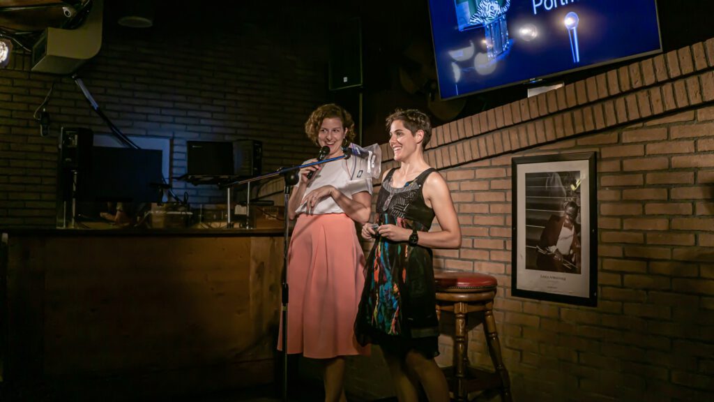 Two women standing together on the Poetry Slam stage