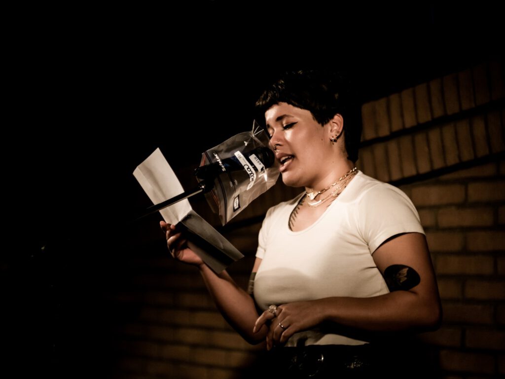 Woman reading from papers at the Poetry Slam microphone